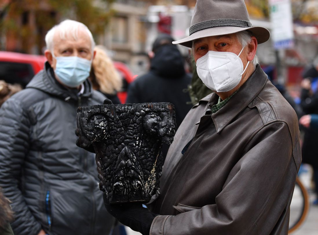 Pete Grenell, a member of the historic Middle Collegiate Church, which was destroyed in a 6 alarm fire, in the East Village early on Saturday morning in New York City, holds a piece of a burnt column given to him by a NYFD fireman.